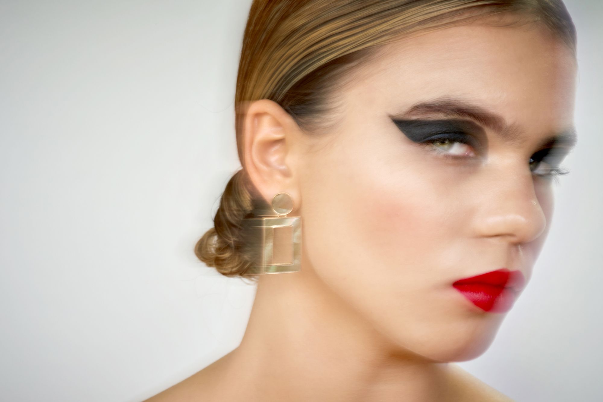 Kleopatra Stellung - Abbildung einer Frau mit stark geschminkten Augen und rotem Lippenstift