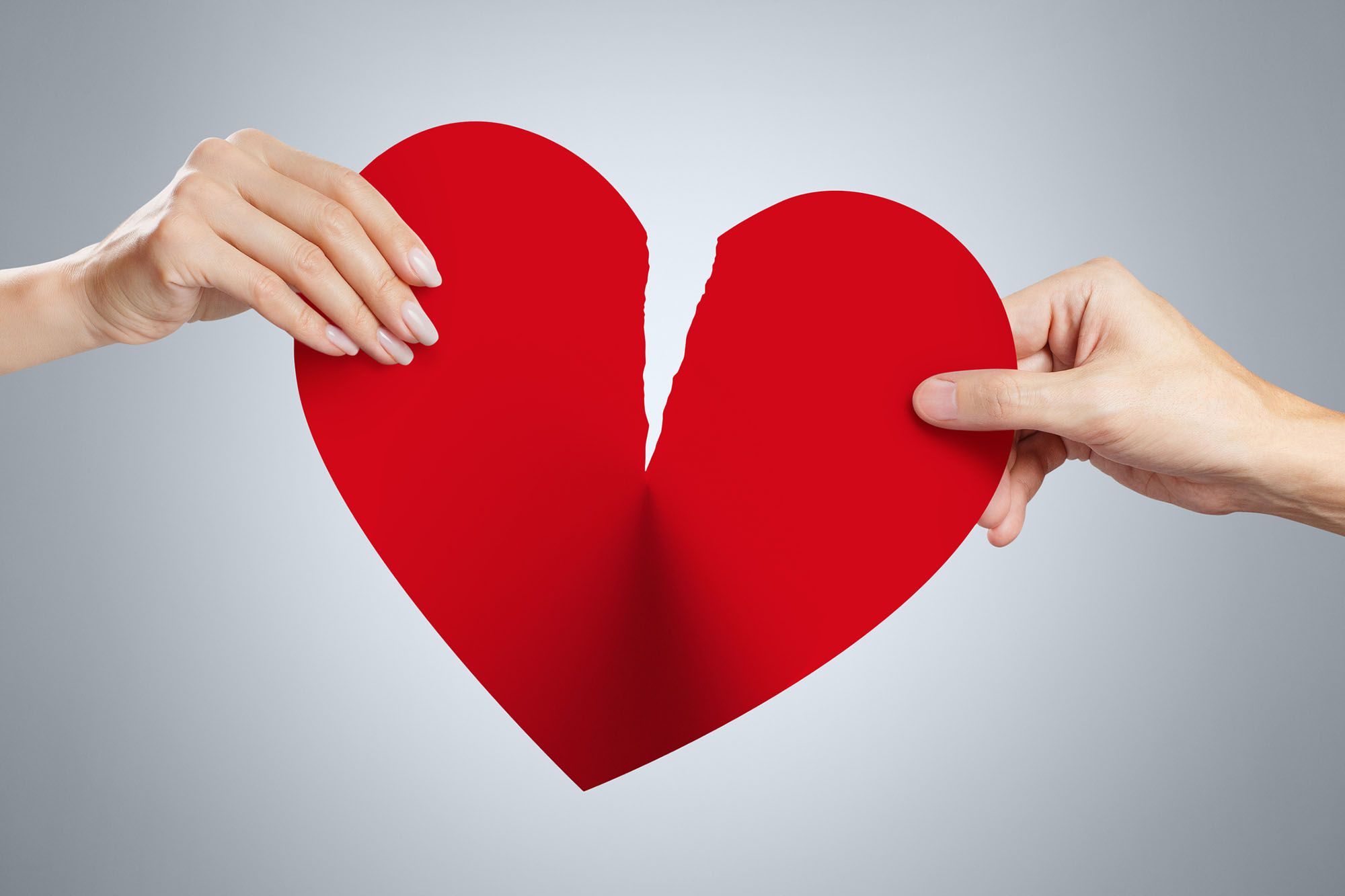 Filme gegen Liebeskummer - Abbildung eines Papier-Herzens, welches von zwei Händen zerrissen wird.