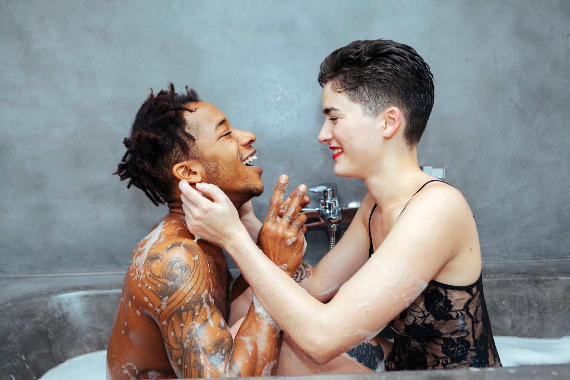 Kitzel Fetisch - Abbildung einer Frau und eines Mannes, welche lachend in der Badewanne sitzen.