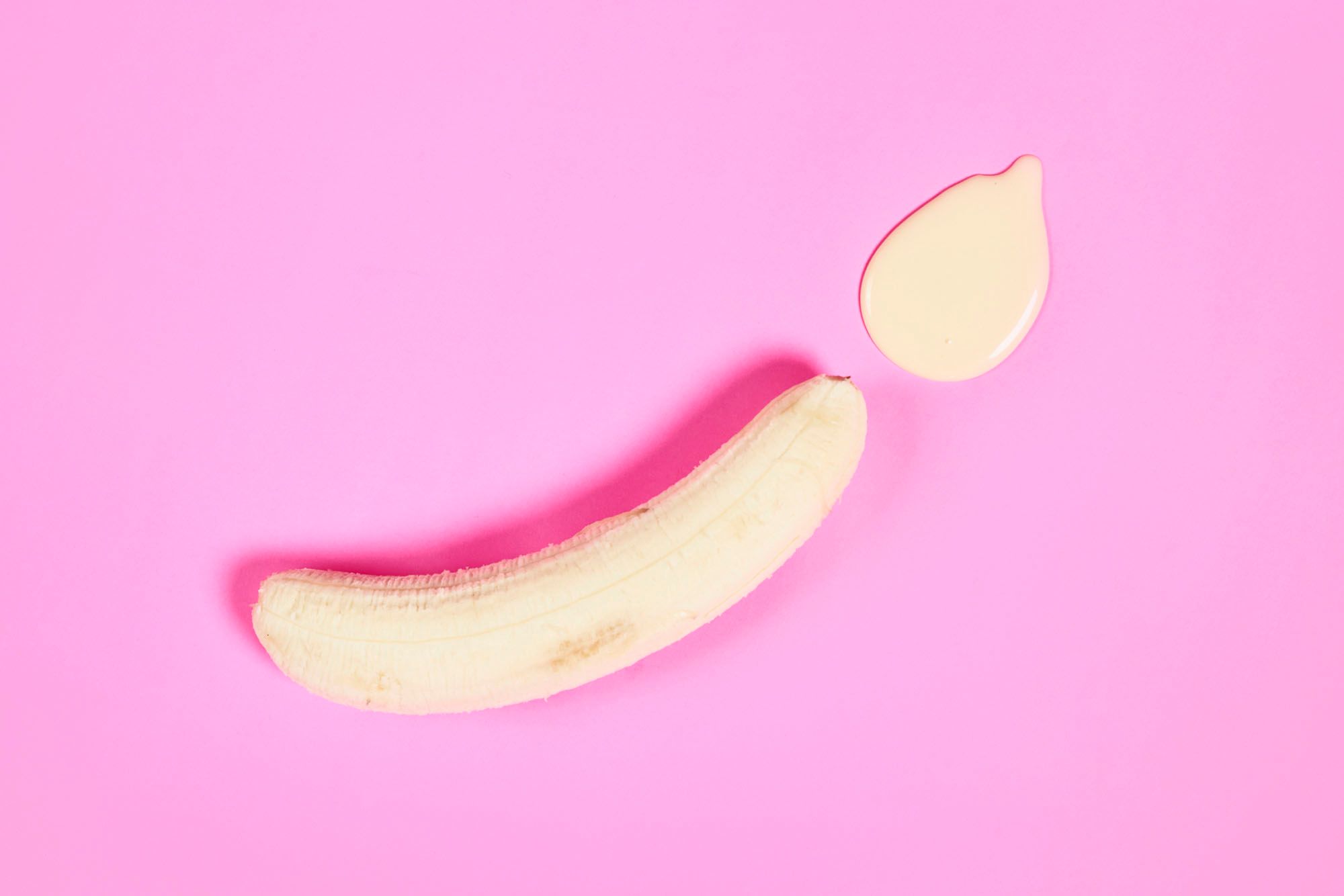 Eine Banane, an deren einem Ende eine Lache gelblicher Flüssigkeit ist