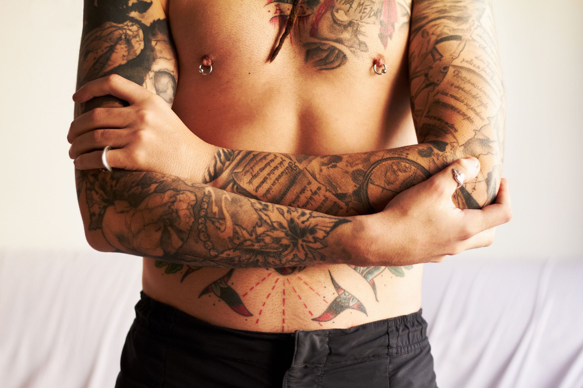 Mann mit gepiercten Nippeln und Tattoos