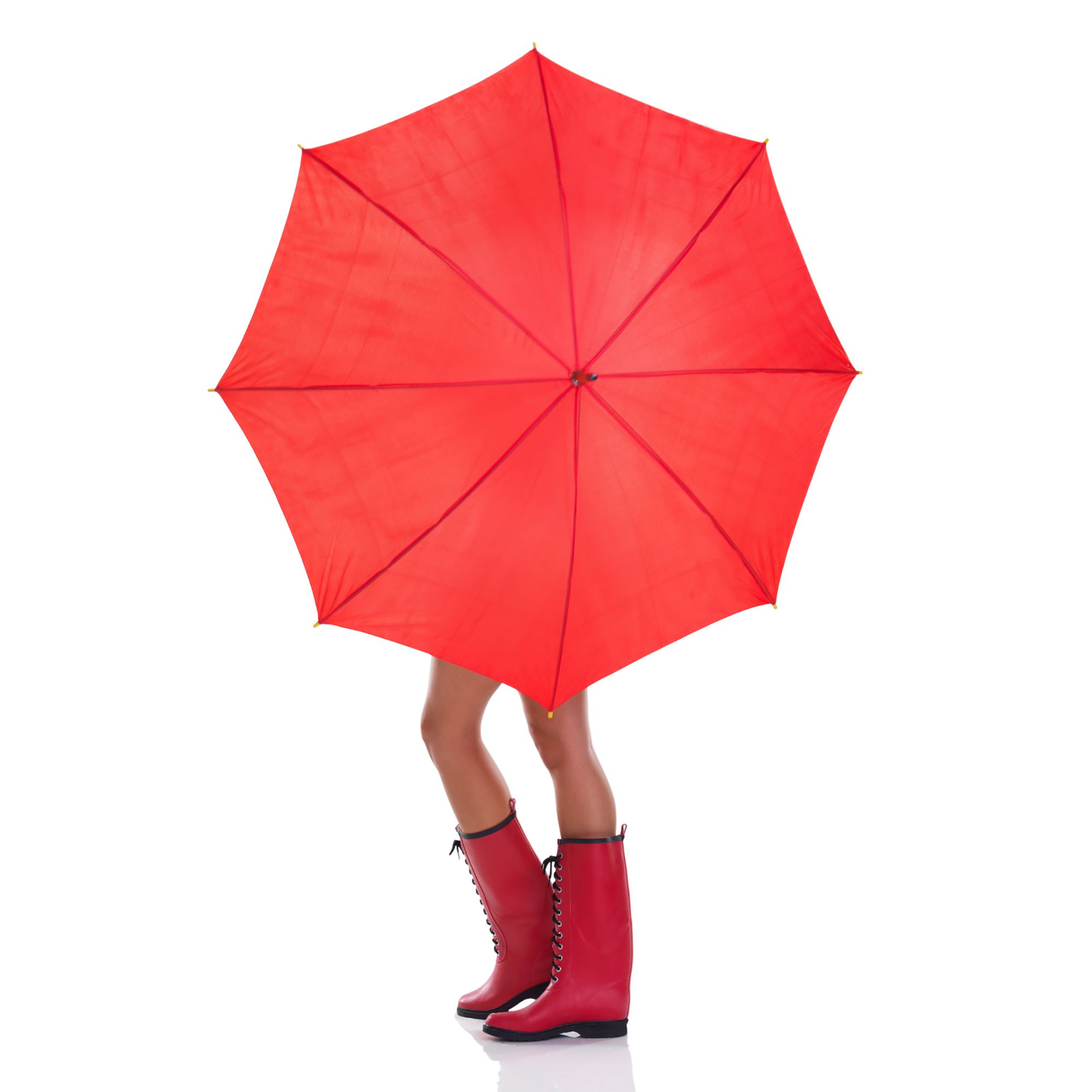 Frau in roten Gummistiefeln, die ihren Körper mit einem roten Regenschirm verdeckt