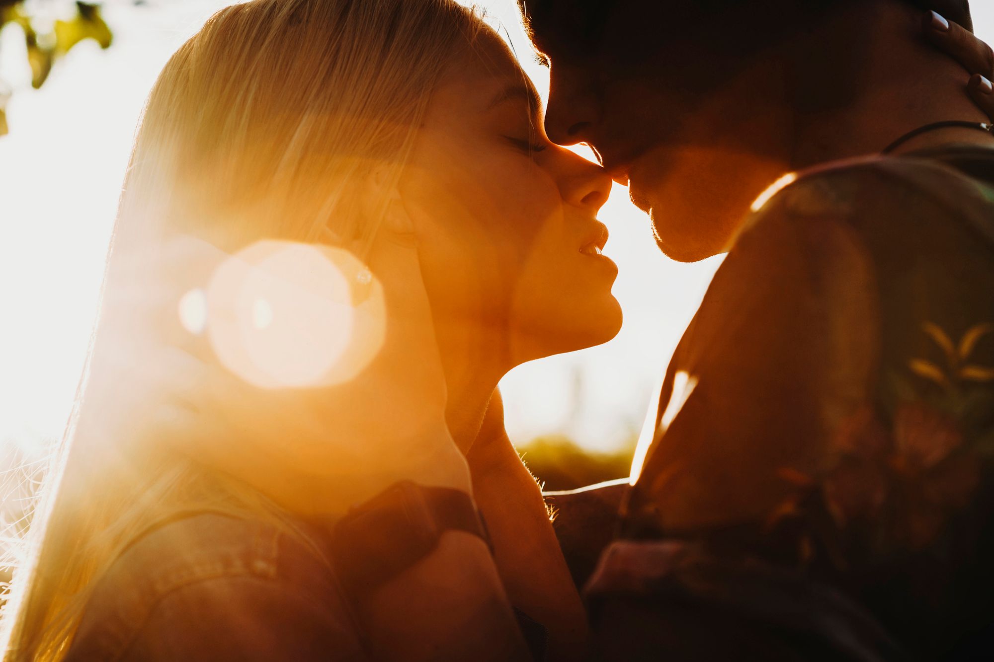 Mann und Frau küssen sich im Sonnenlicht
