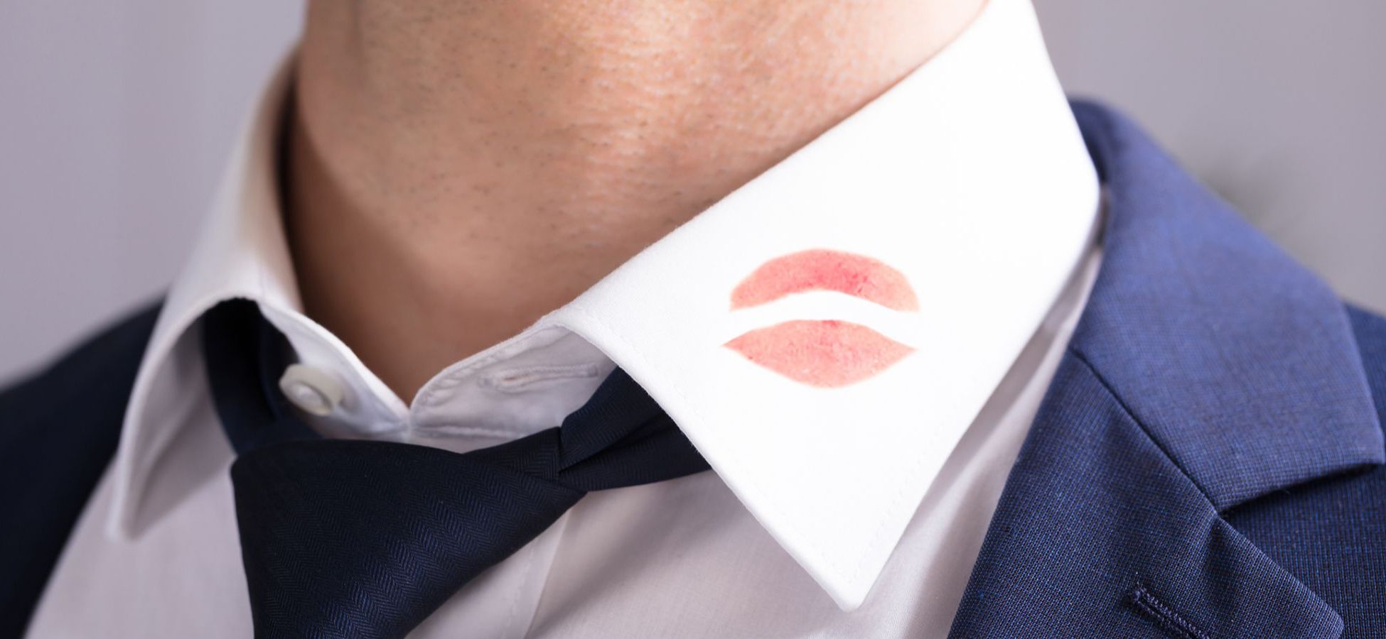Mann hat einen Lippenstift-Abdruck am Hemdkragen