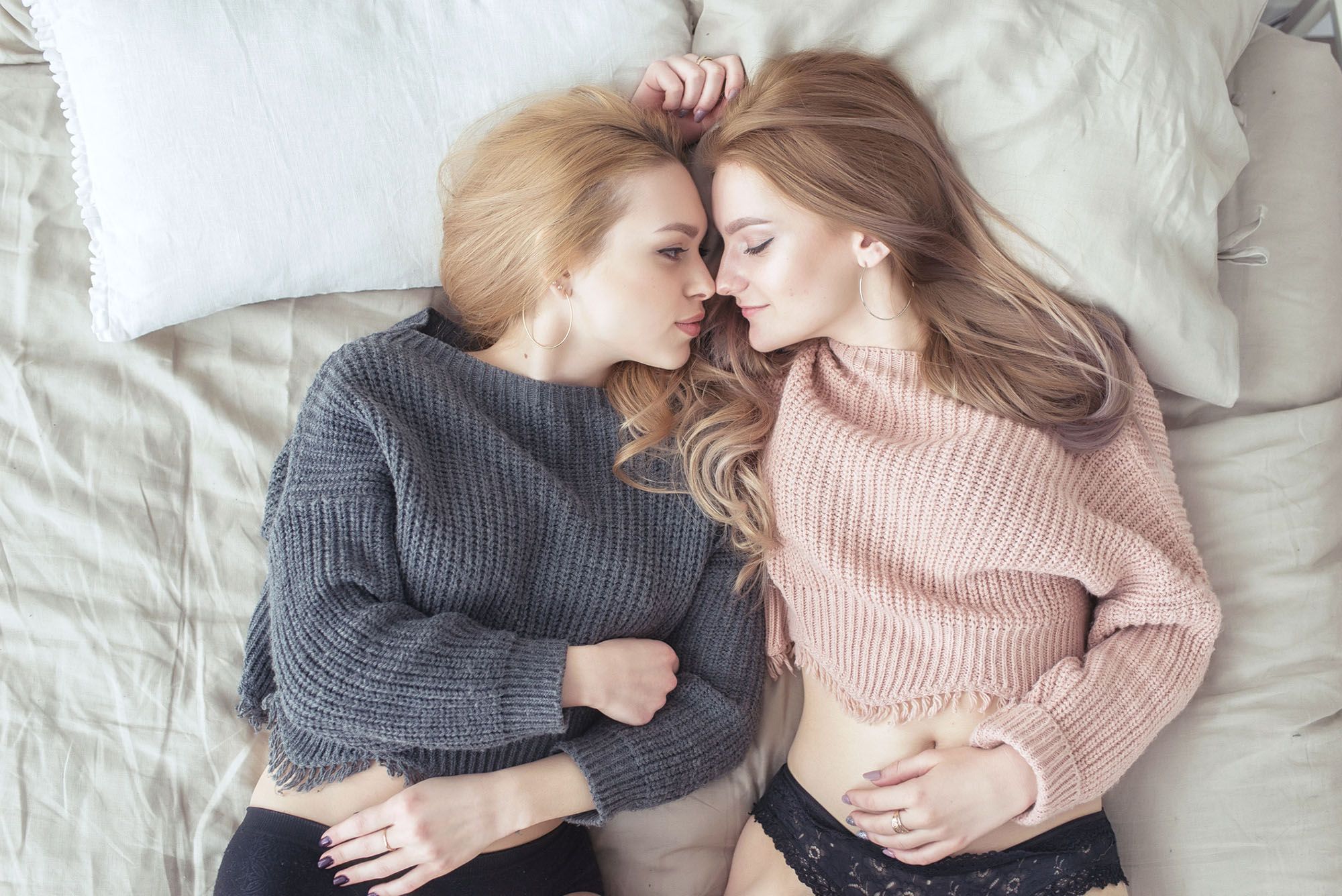 2 bisexuelle Frauen liegen nebeneinander im Bett