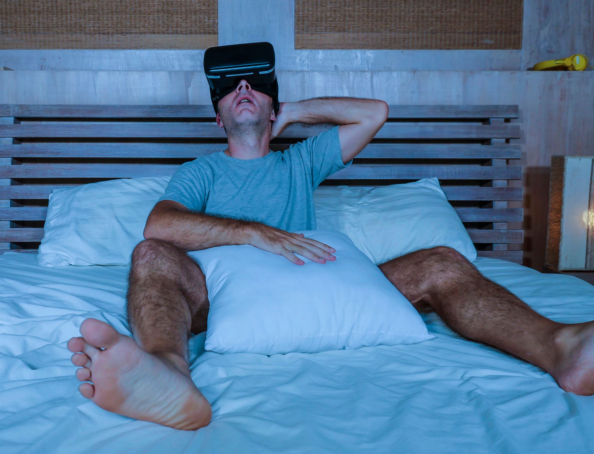 Cybersex: Mann liegt im Bett und trägt eine VR-Brille