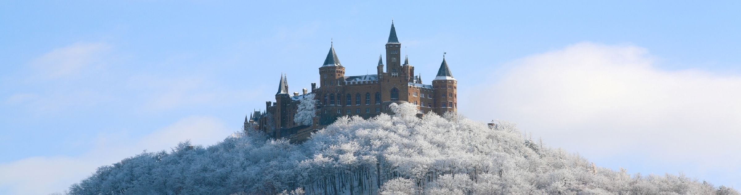 Eine Burg steht auf einem schneebedeckten Hügel.