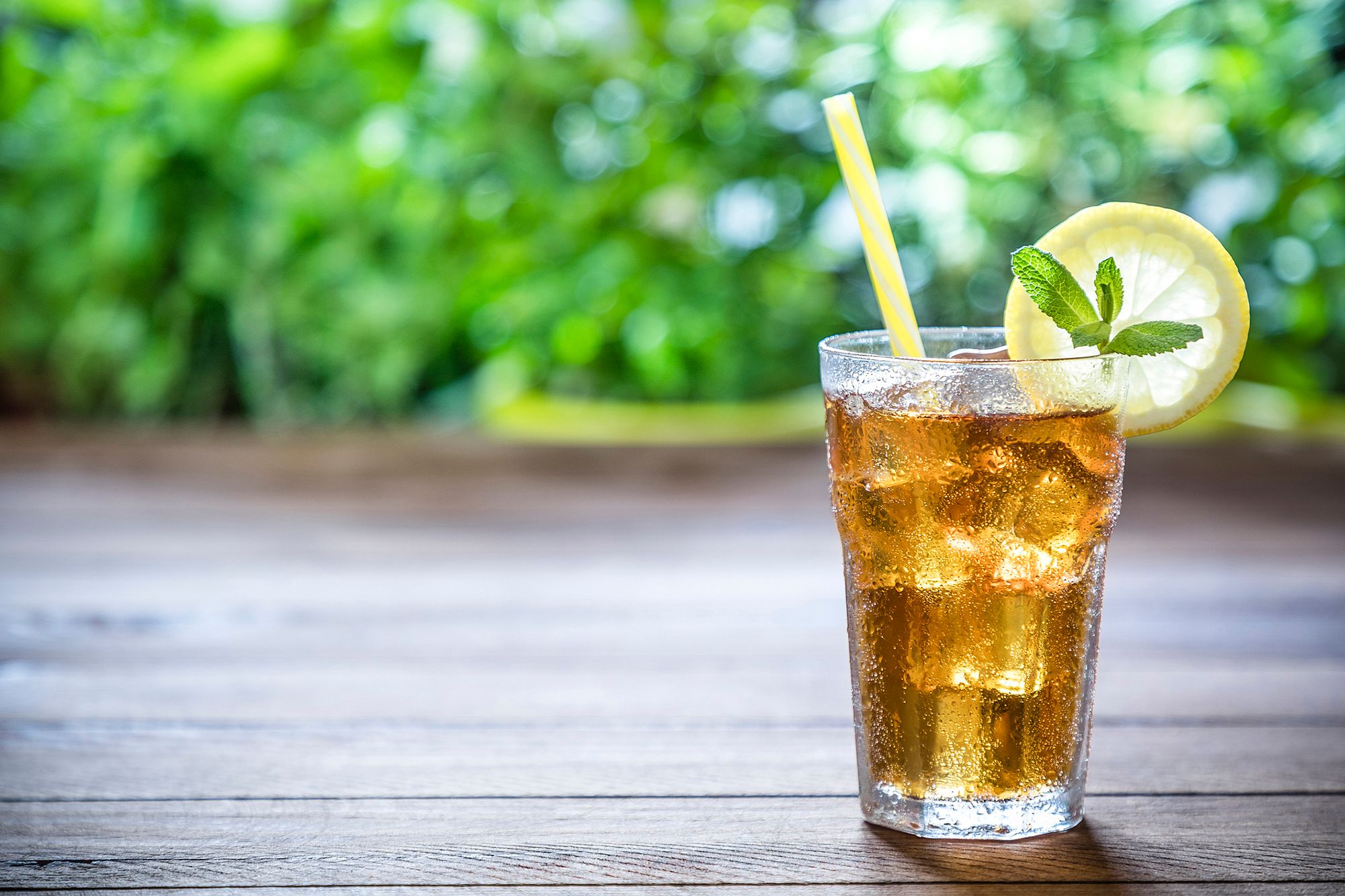 Goldener Cocktail mit Strohhalm und Zitrone