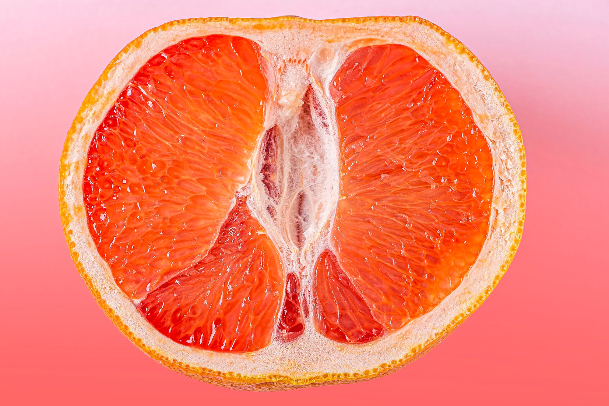 Halbierte Orange vor orangenem Hintergund
