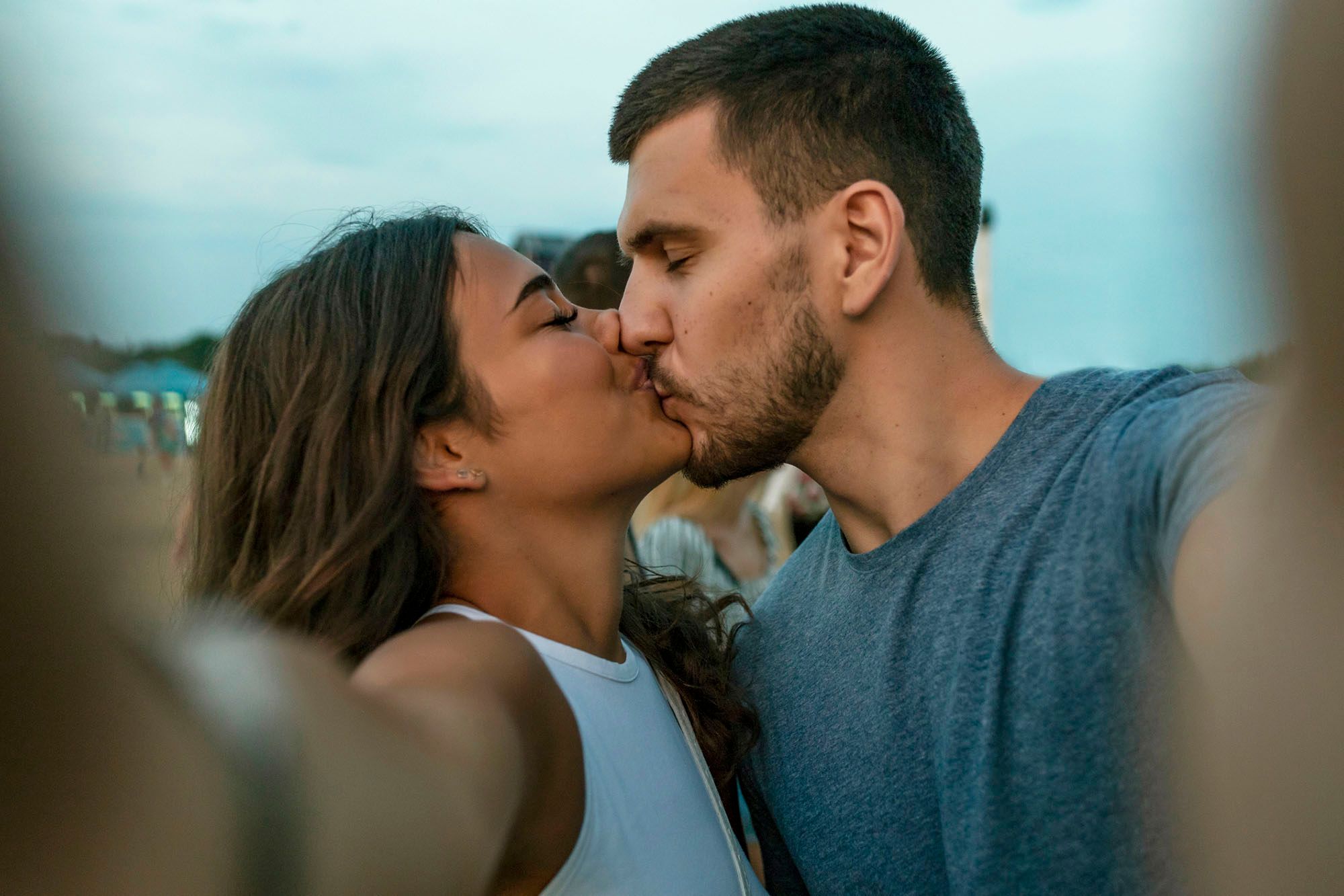 Frau und Mann küssen sich und machen ein Selfie