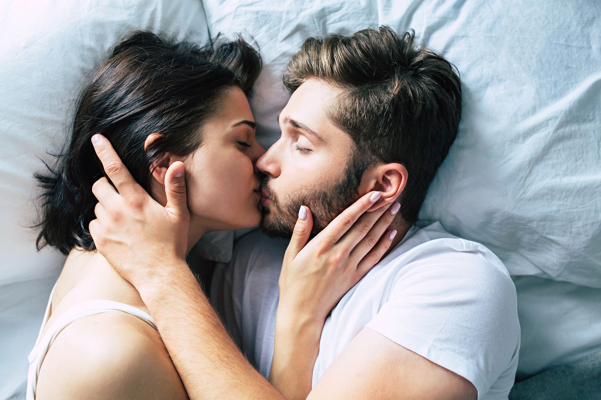 Paar küsst sich im Bett