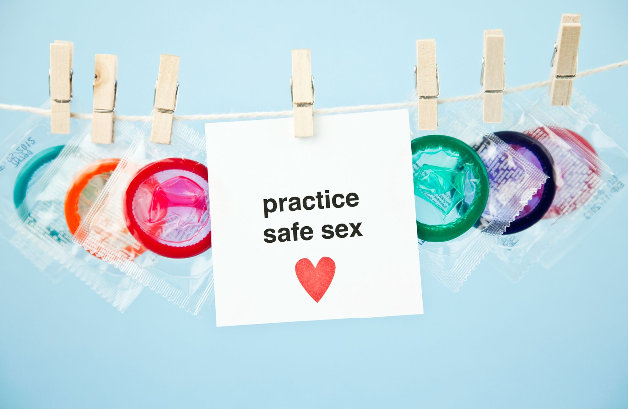Wäscheleine, an der verschiedene Kondompackungen hängen