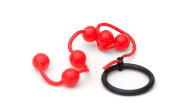 Eine rote Analkette mit Kugeln daran auf einem weißen Untergrund