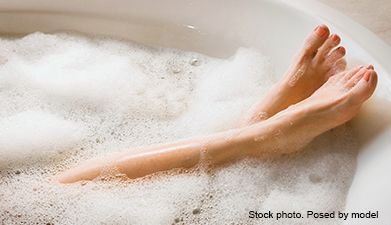 Füße die aus einer Badewanne herausschauen