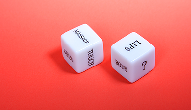 Erotisches Würfel-Spiel vor einem roten Hintergrund