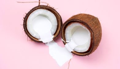 Zwei Kokosnusshälften aus denen Kokosmilch rausläuft