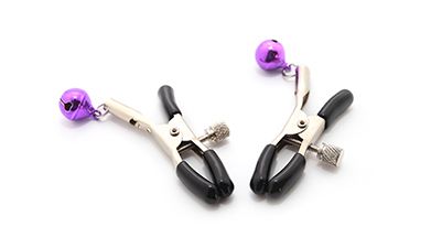 Zwei schwarz-metallene Nippelklemmen mit jeweils einem kleinen lilanen Glöckchen daran