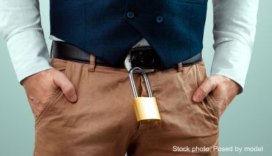 Ein Mann der vor seinem Schritt ein Vorhängeschloss hängen hat