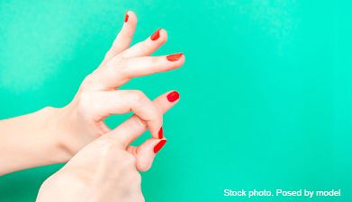 Zwei Hände mit roten Nagellack die das Geschlecht Handzeichen symbolisieren