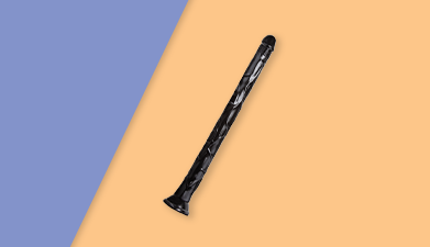 Der Riesendildo 'Black Mamba' von Blush Novelties vor einem orange-lilanen Hintergrund