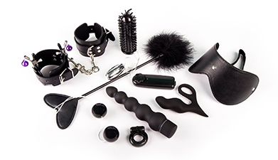 Schwarze Sextoys die nebeneinander liegen vor einem weißen Hintergrund