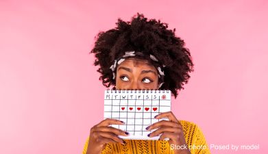 Eine Frau die einen Kalender in der Hand hält auf dem Herzen abgebildet sind