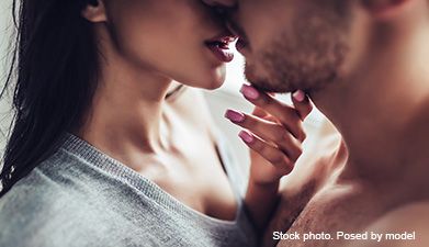 Eine Frau und ein Mann deren Lippen sich fast zum Kuss treffen