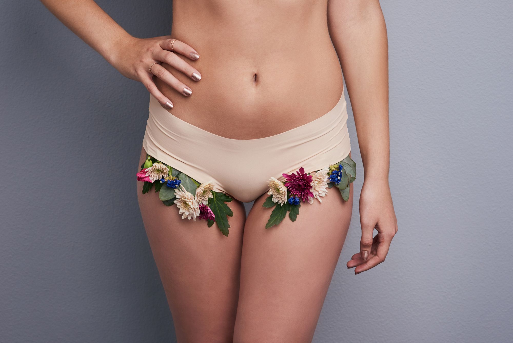 Frau in Slip mit Blumen, die zur Seite unter dem Slip hervortreten