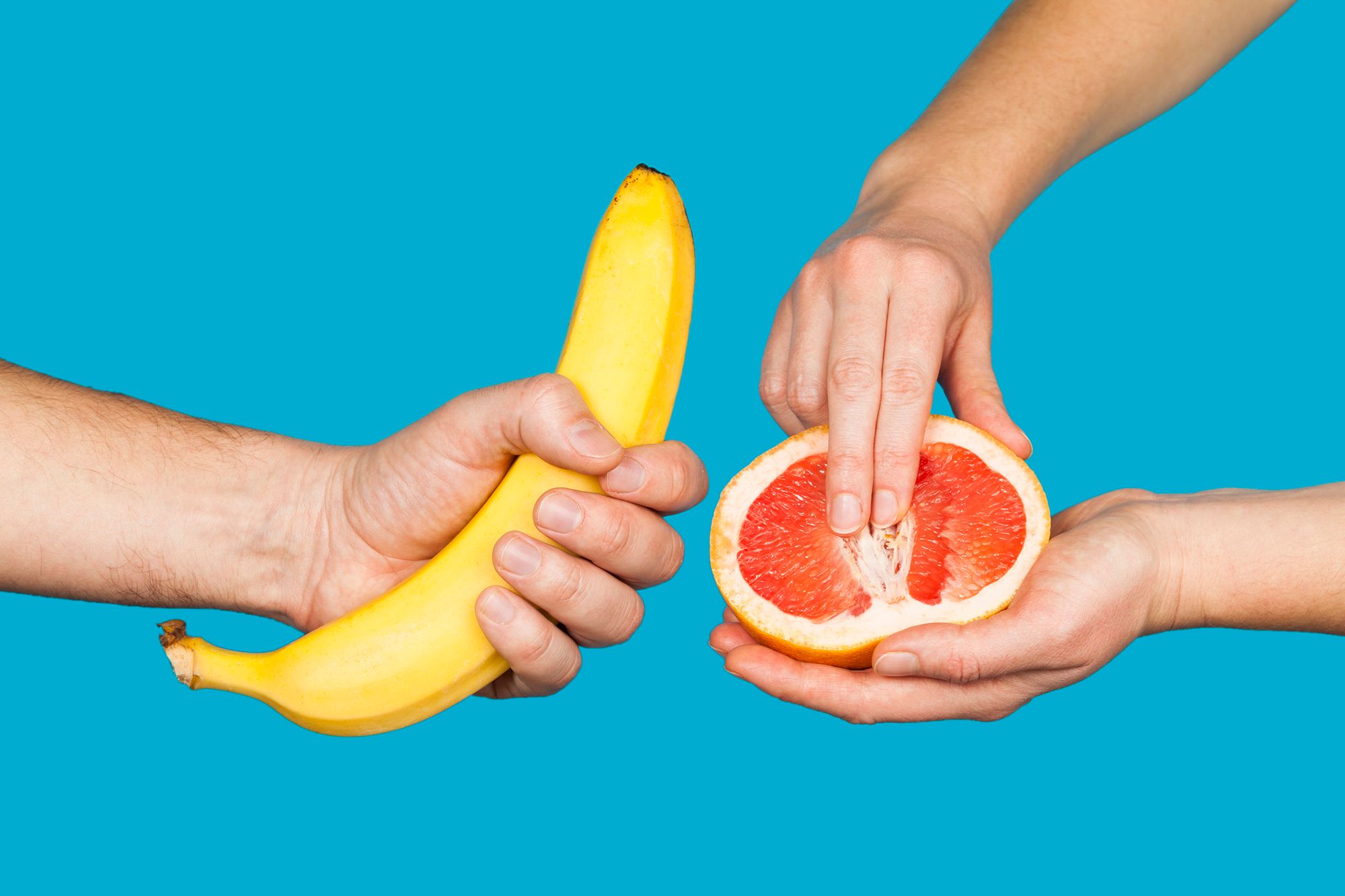 Hände, die eine Banane und eine halbe Orange halten als Symbolbild für Selbstbefriedigung