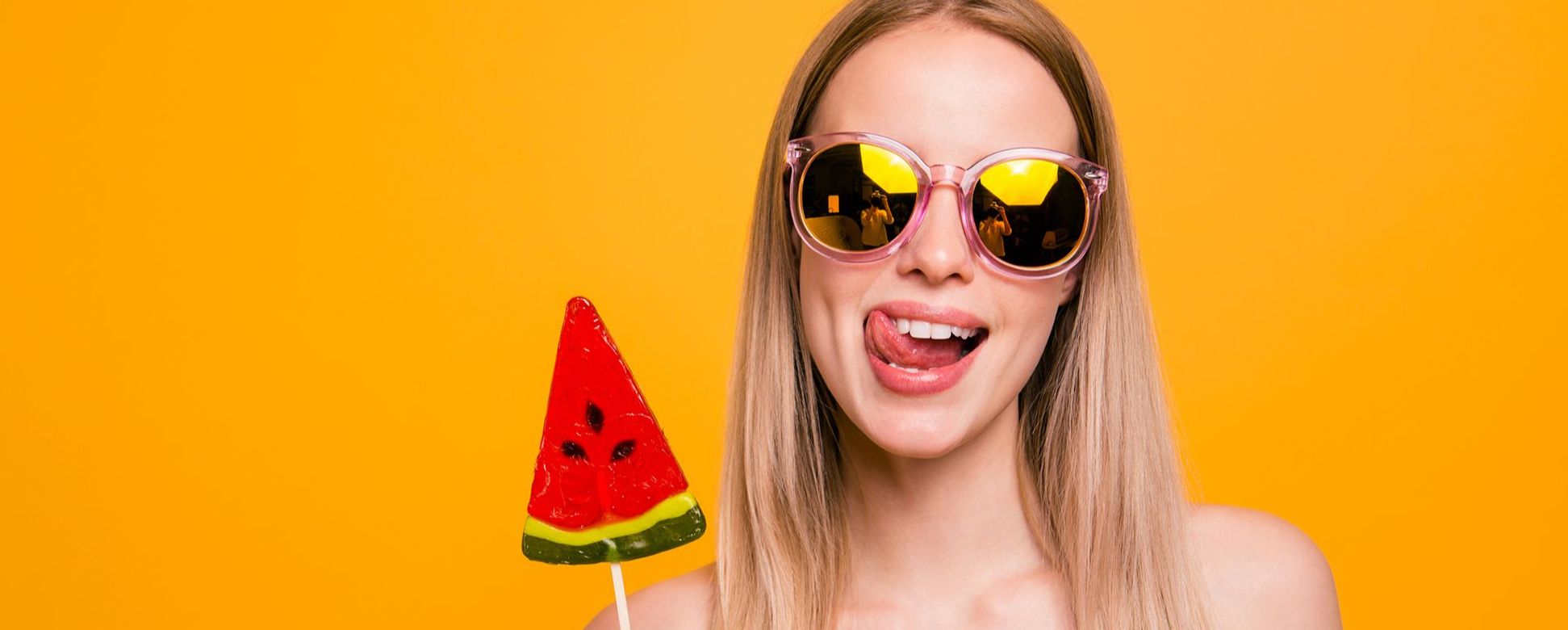 Frau mit Sonnenbrille mit Melonen-Lolli