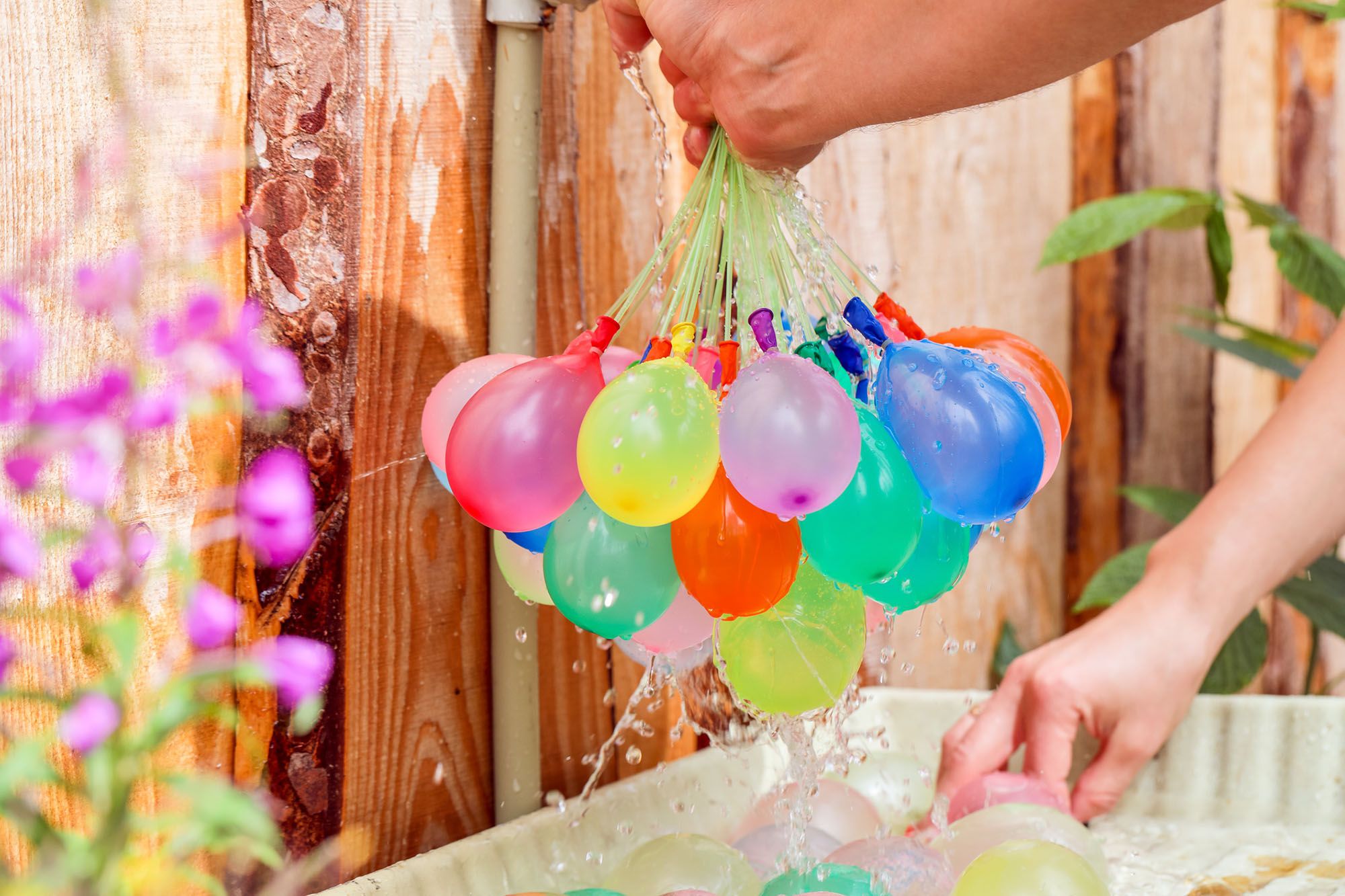 Mann hält viele gefüllte Wasserbomben in der Hand