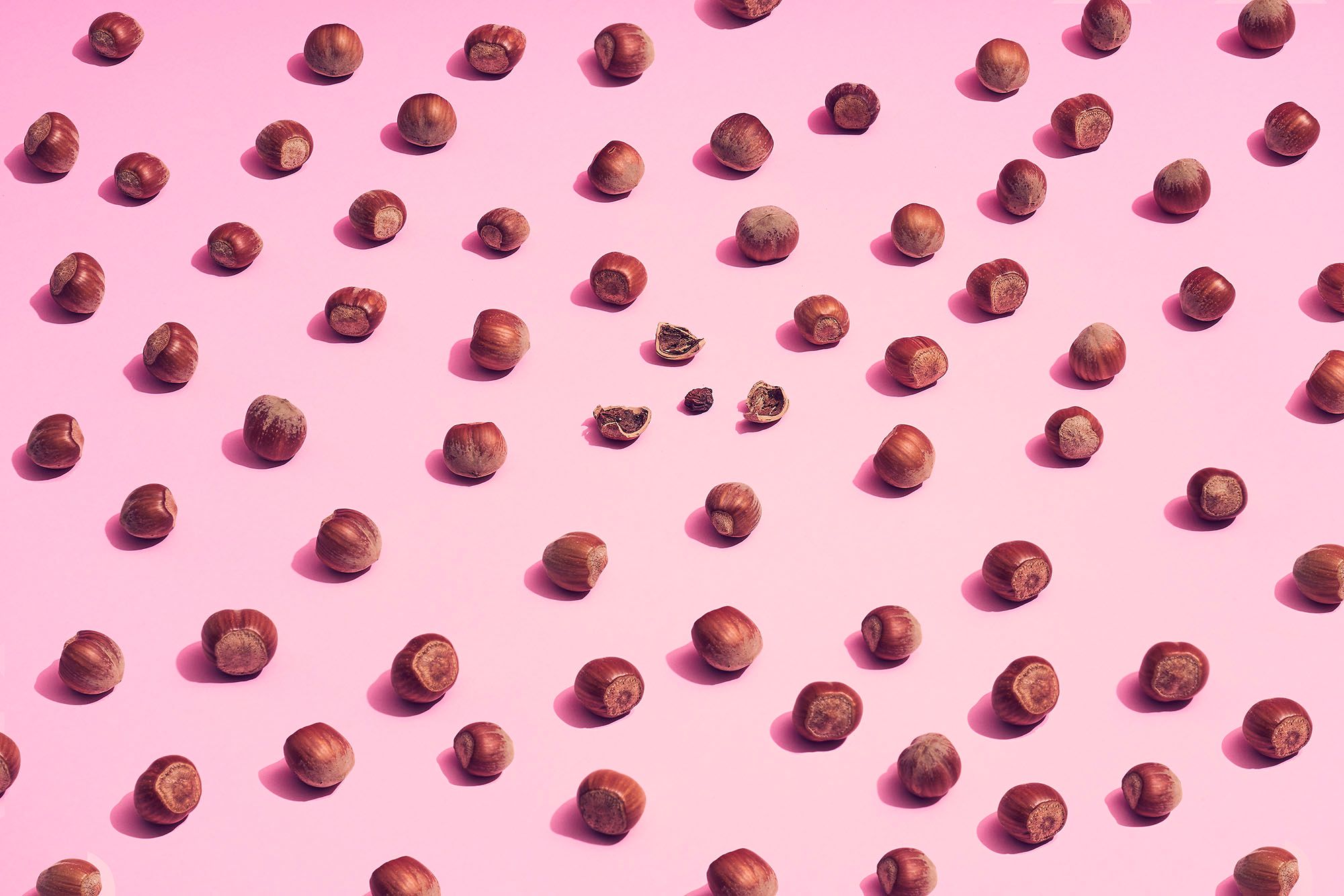Viele Nüsse auf rosa Hintergrund