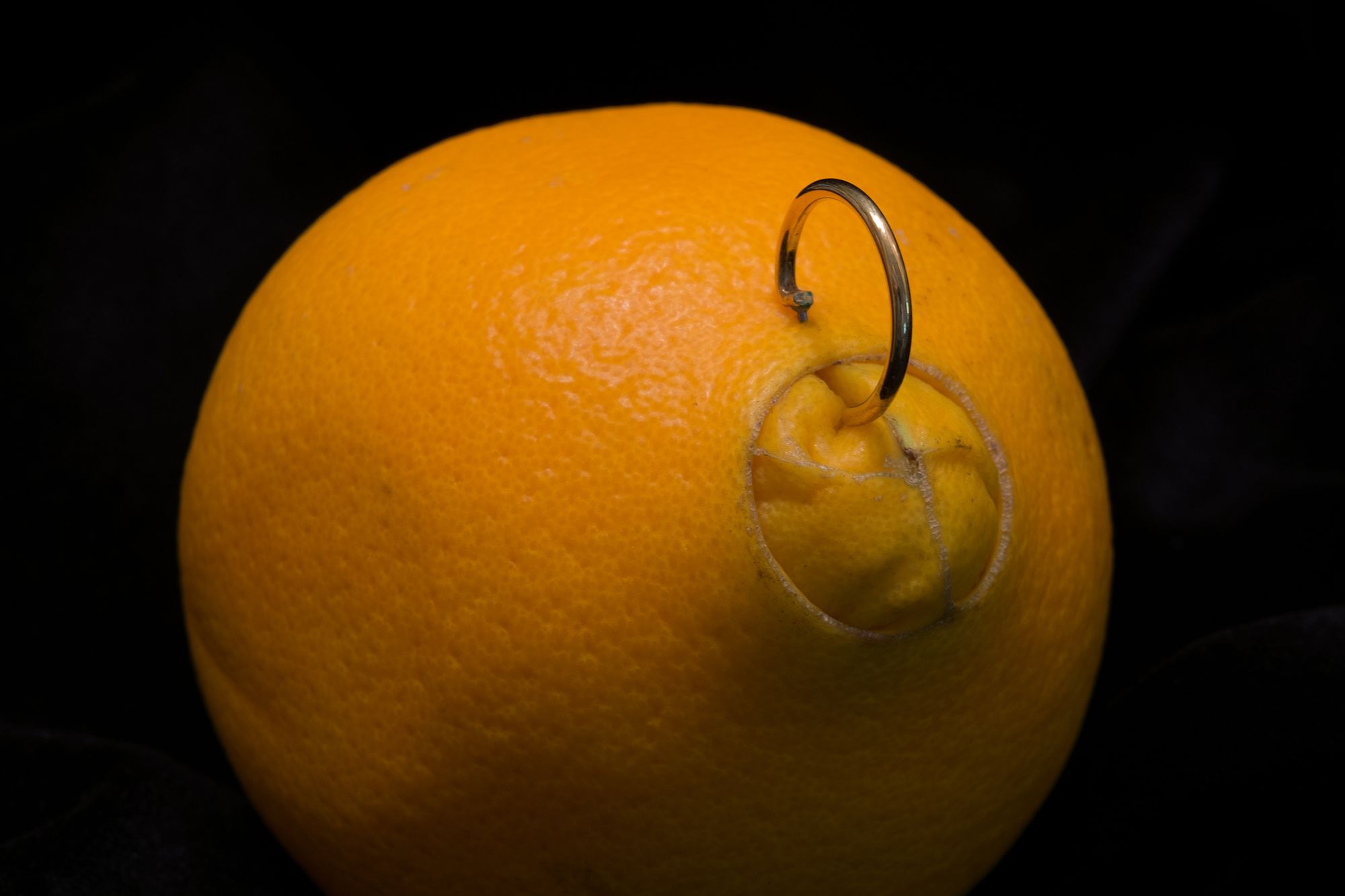 Orange, in der ein Piercing angebracht ist