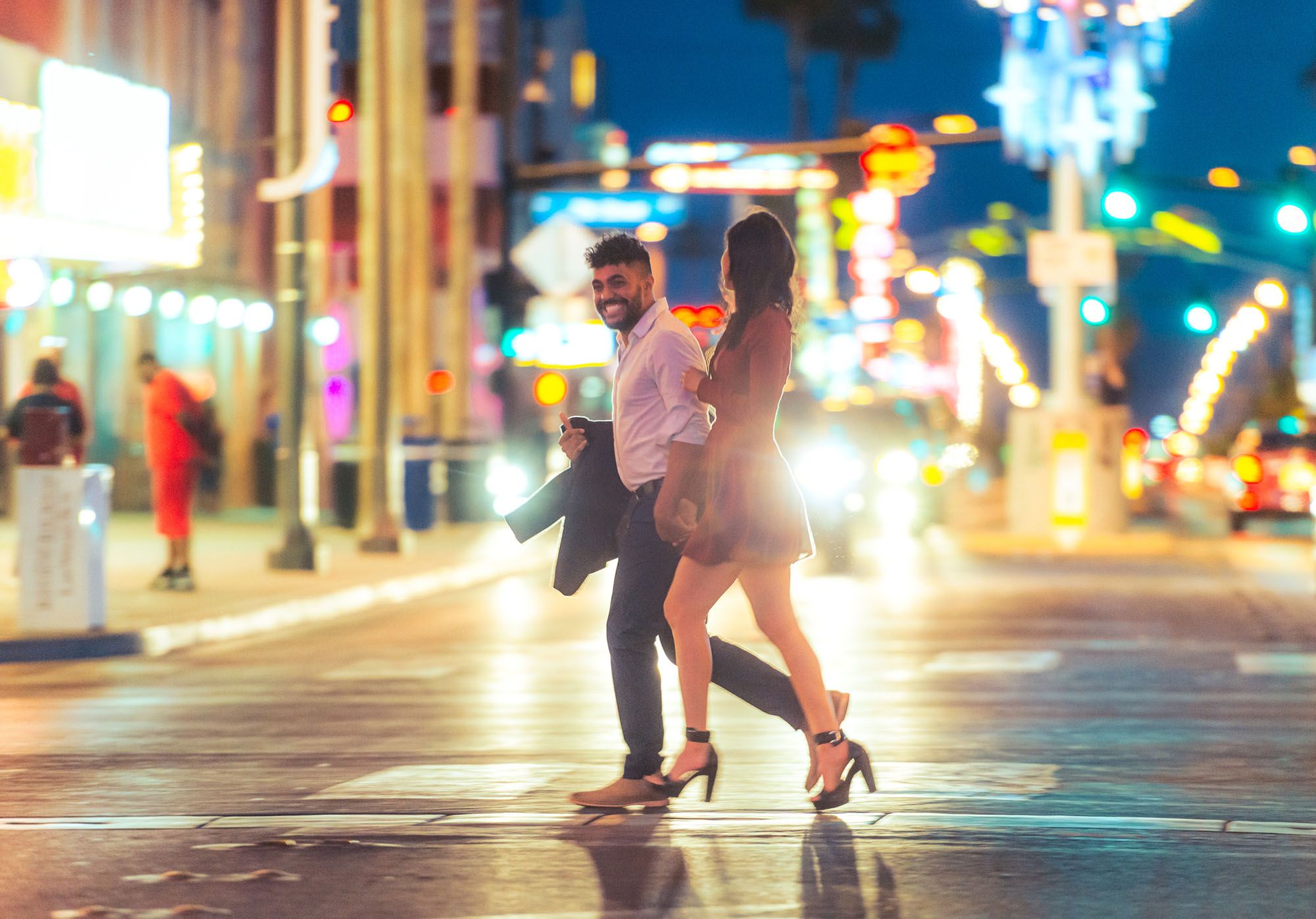 Mann und Frau laufen bei Nacht über eine Straße