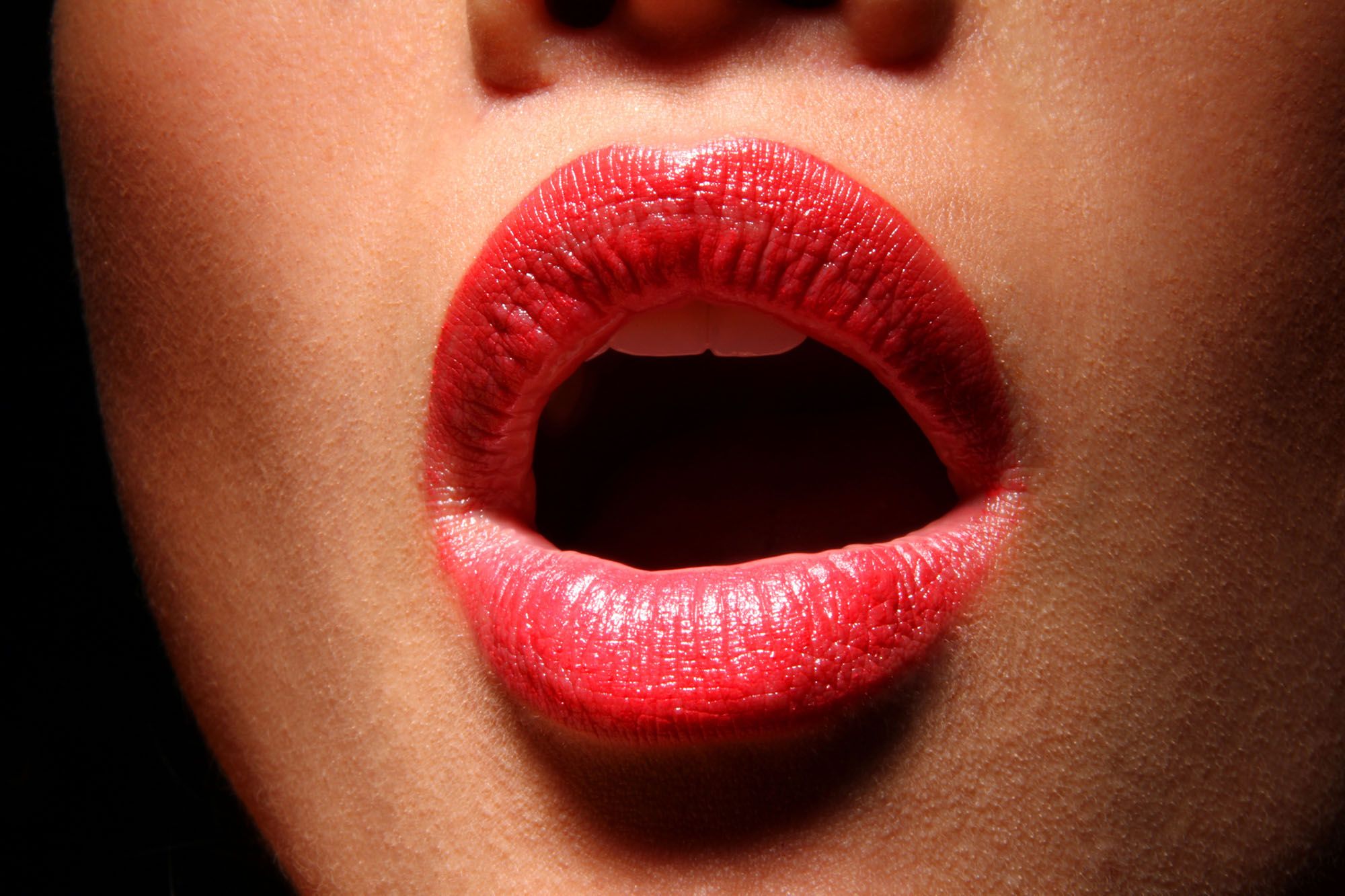 Offener Mund mit rotem Lippenstift als Nahaufnahme