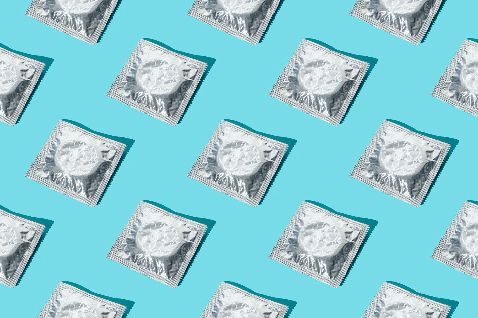 Viele Kondome in silberner Packung auf blauem Hintergrund
