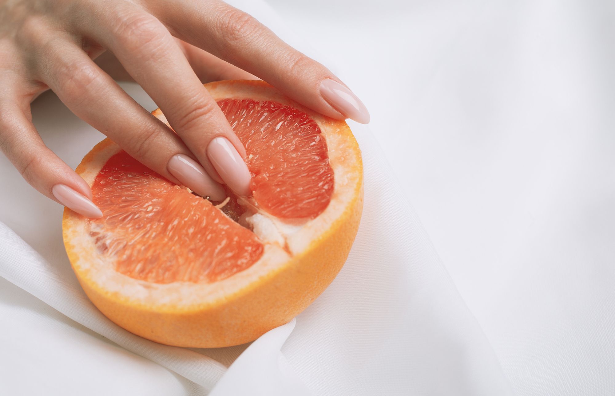 Halbe Orange, in die 2 Finger eingeführt werden