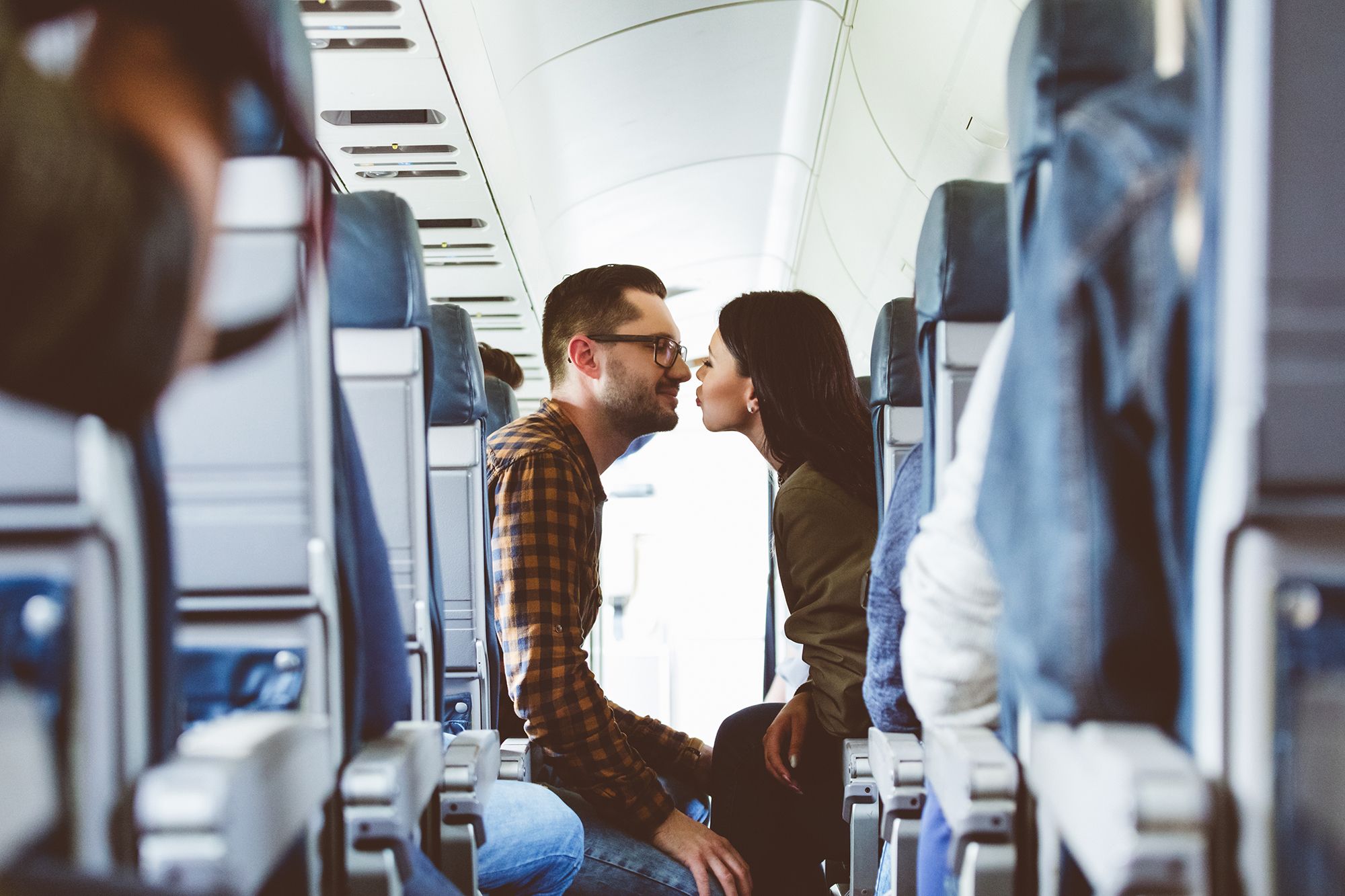 Ein Pärchen das sich im Flugzeug küsst