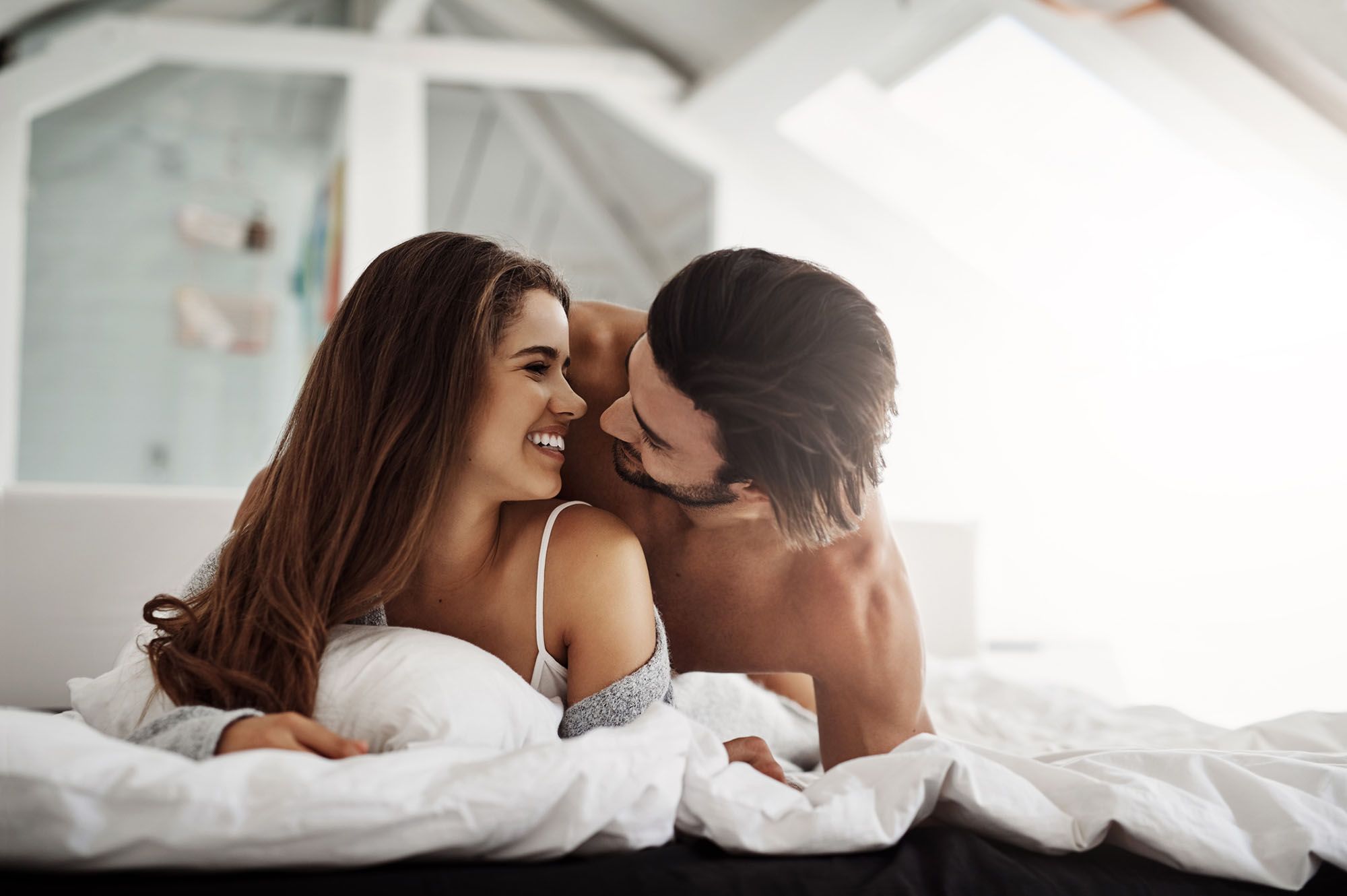 Mann und Frau kuscheln im Hotelbett