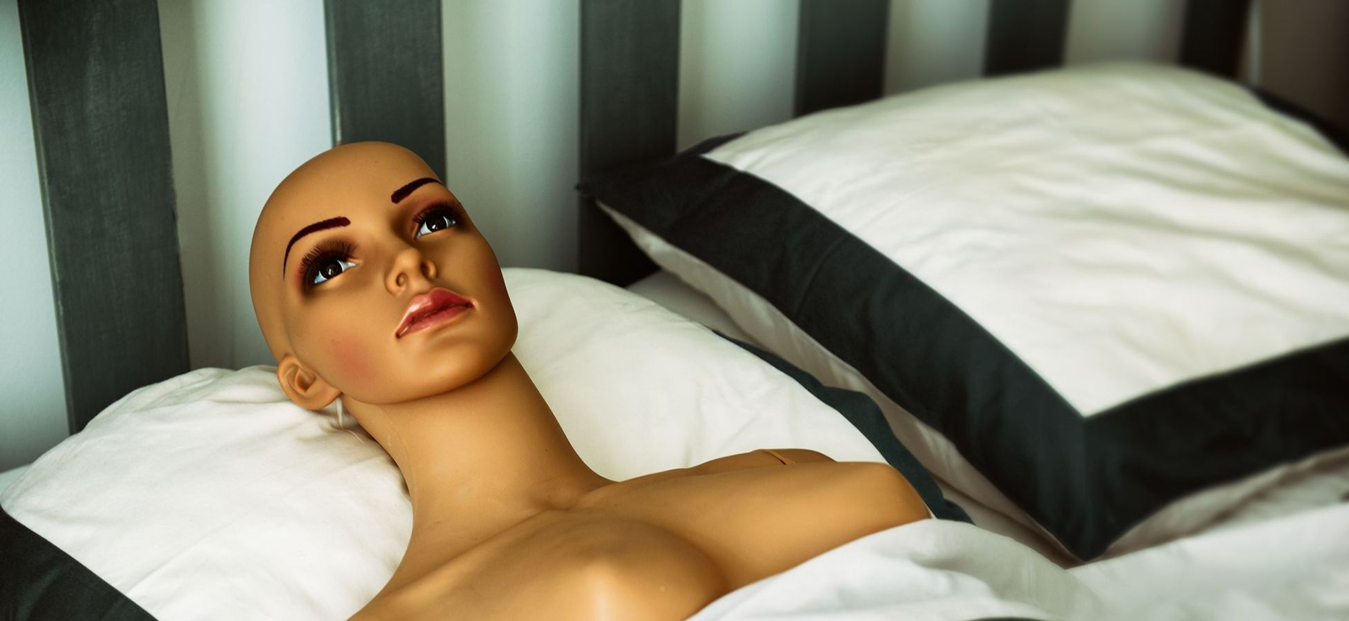 Weiblicher Sex-Roboter liegt in einem Bett