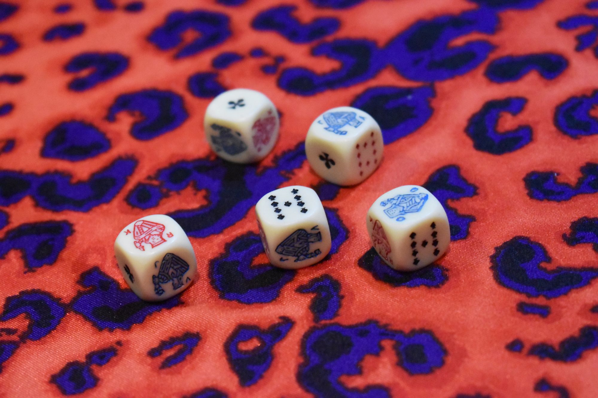 5 Spielwürfel auf einem Leopardenmuster
