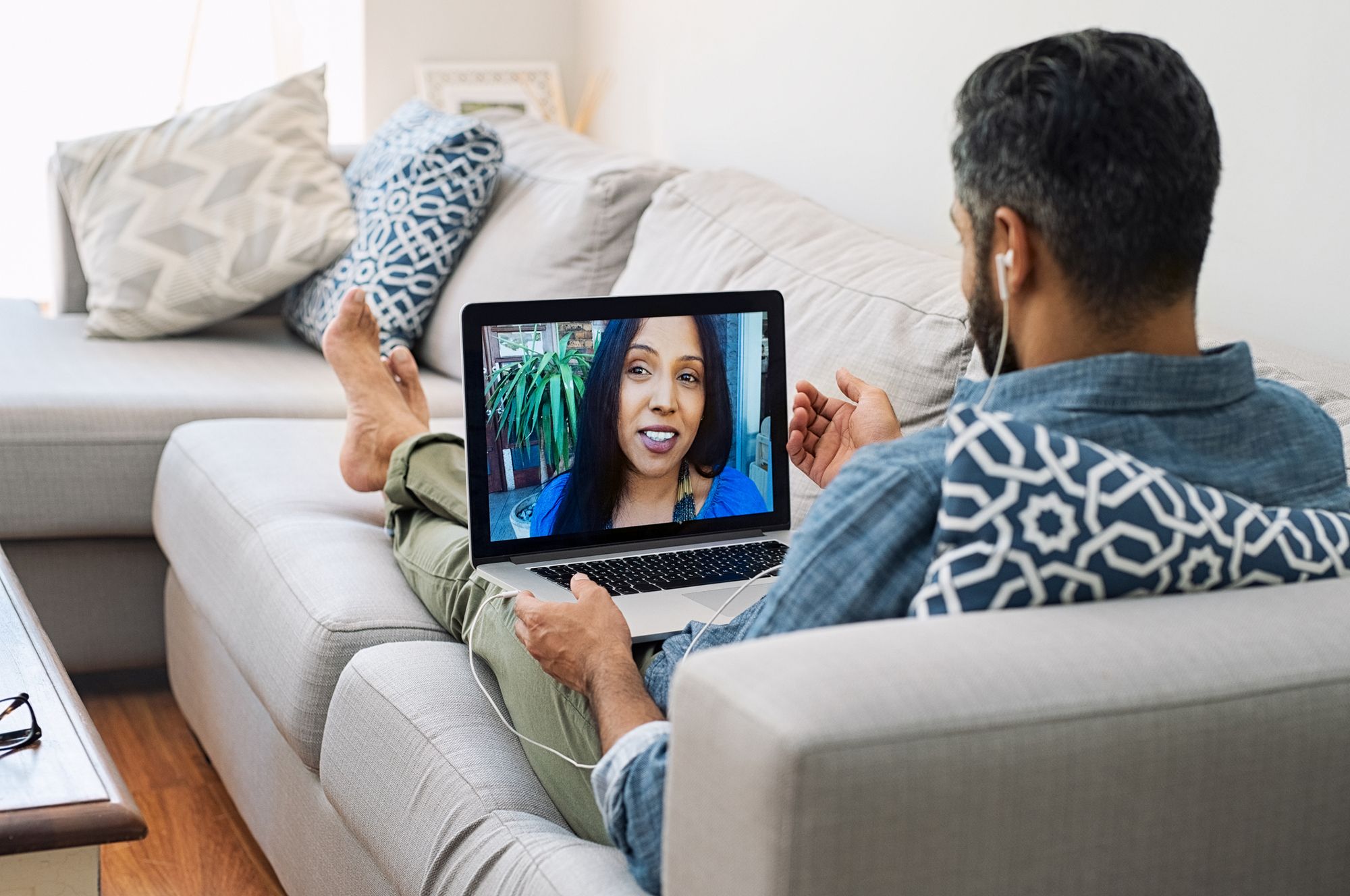 Mann telefoniert via Videocall mit einer Frau.