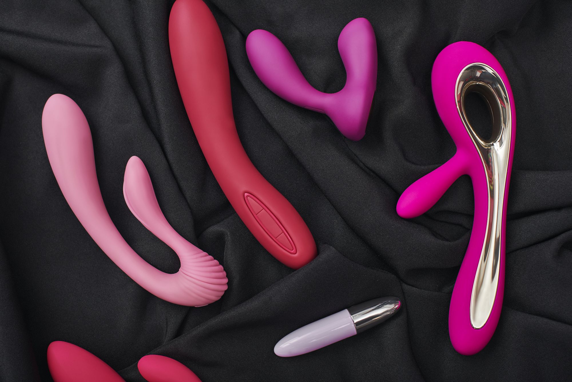 Verschiedene Sextoys aus Silikon auf schwarzem Hintergrund