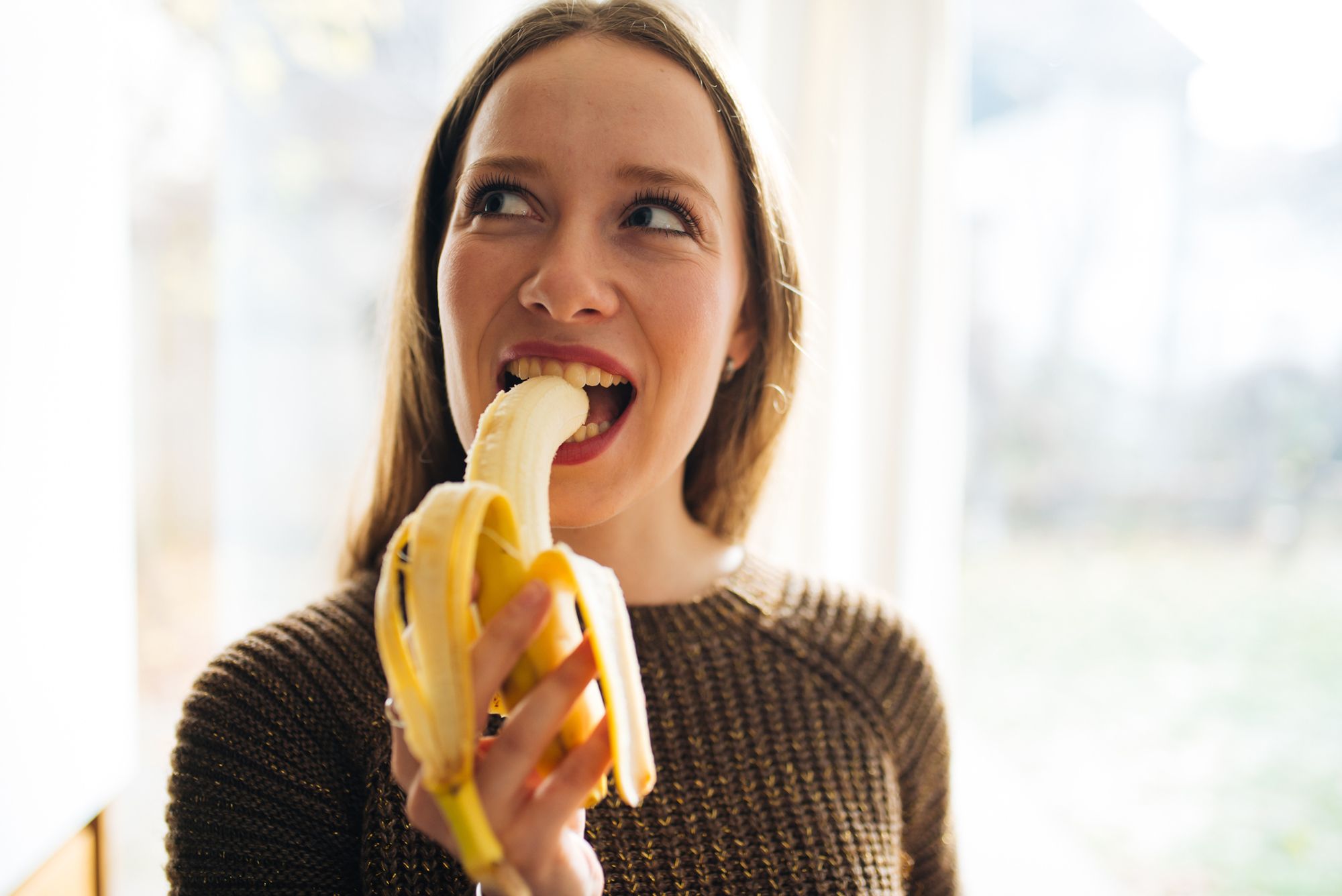 Frau beißt in eine Banane