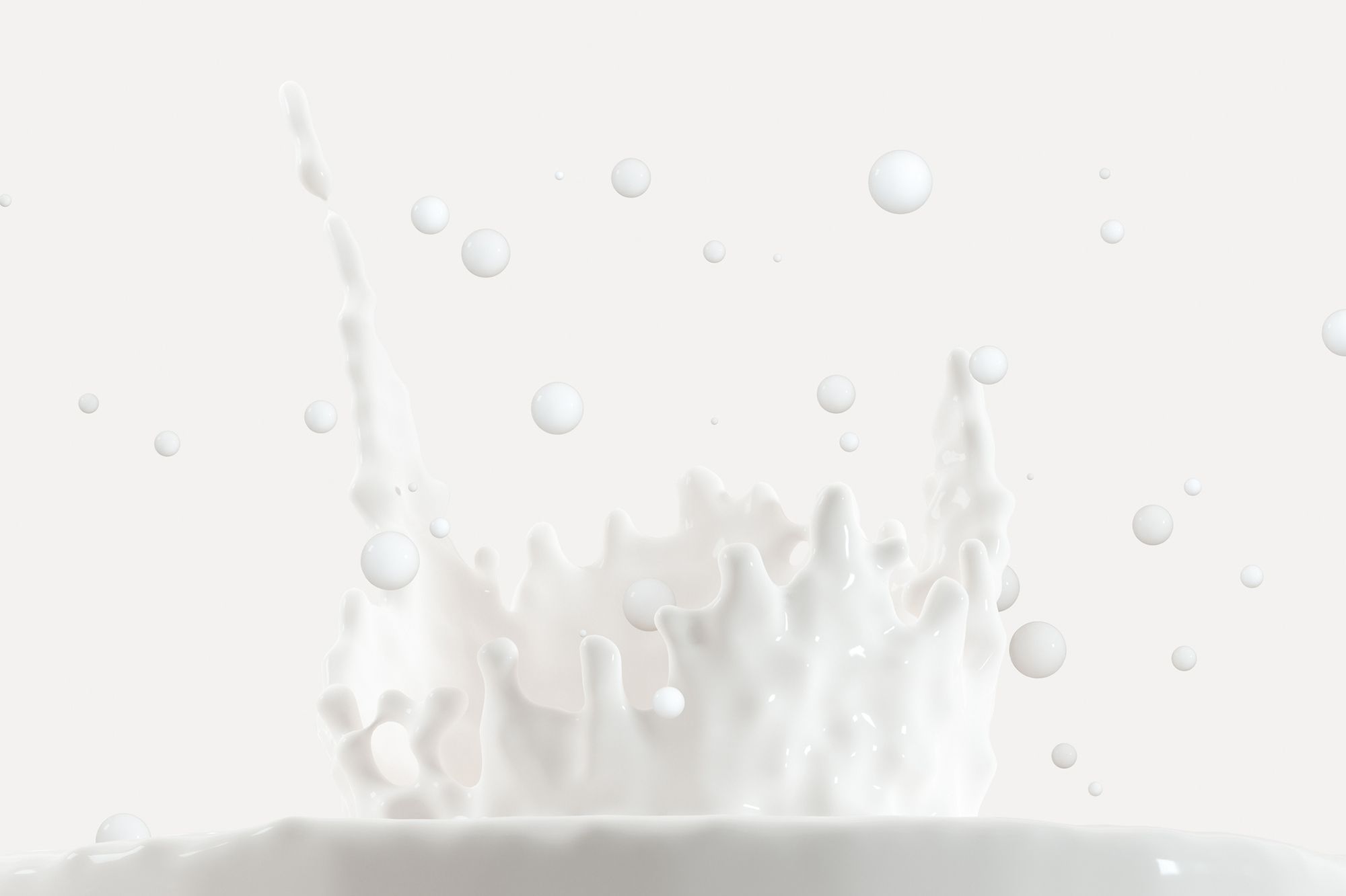 Weiße Flüssigkeit, die nach oben spritzt vor weißem Hintergrund