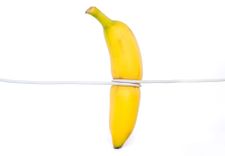 Penisring anlegen - Abbildung einer Banane, die mit einer Schnur abgebunden wird.