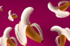 Verschiedene halb geschälte Bananen auf pinkem Hintergrund