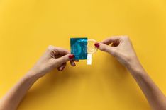 Bestes Kondom - Abbildung von zwei weiblichen Händen beim Öffnen eines Kondoms.