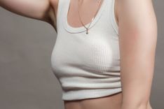 Nippel Spiele - Abbildung eines weiblichen Oberkörpers in einem bauchfreien, weißen Top.