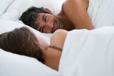 Mann und Frau liegen einander zugewandt im Bett